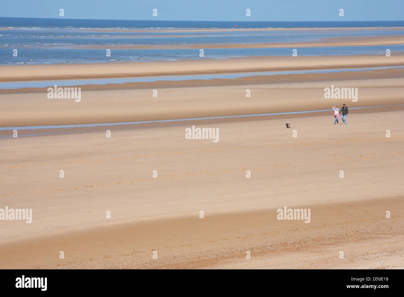 UK; ENGLAND; NORFOLK; HOLKHAM; BEACH; SAND; SEA; PEOPLE; WALKING; Stock Photo