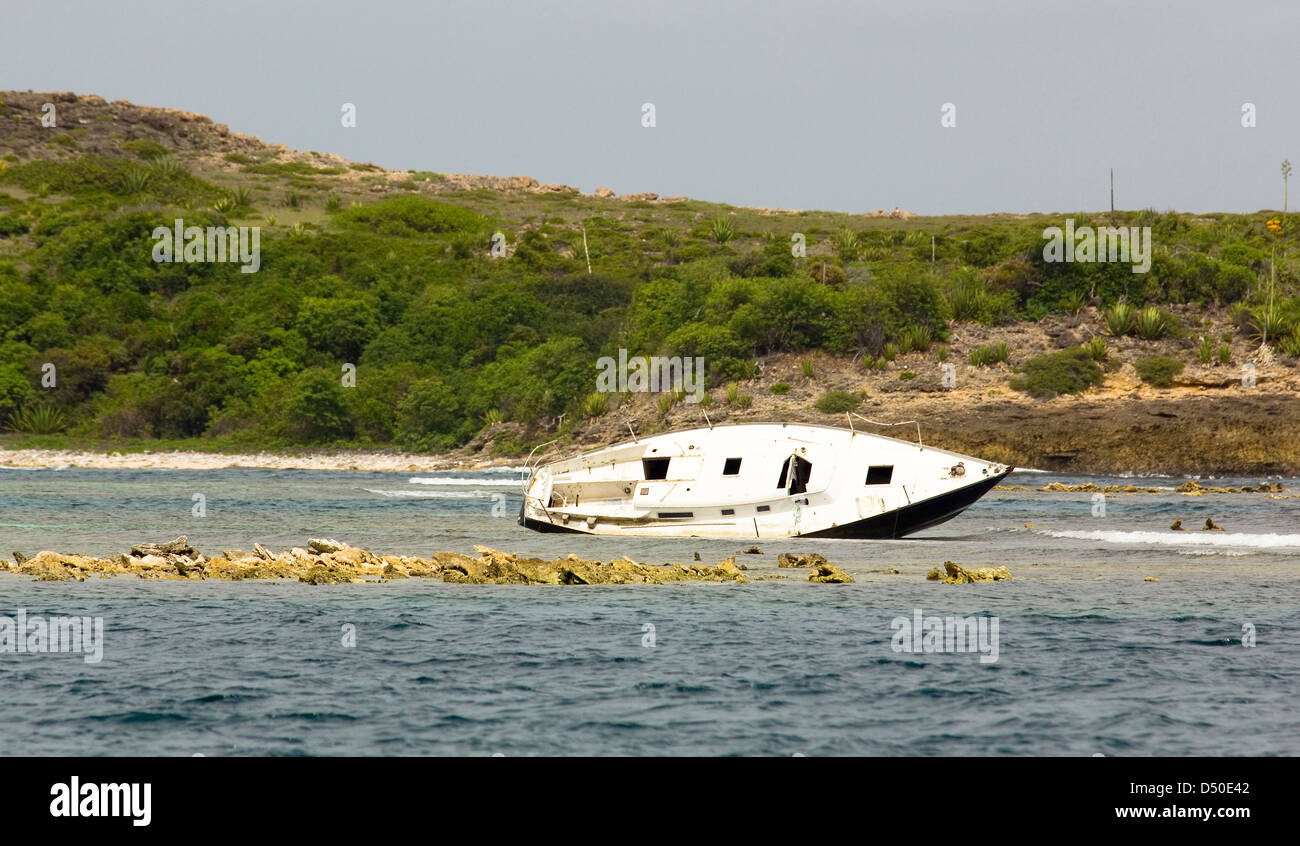 Wrecked Yacht Abandoned on a Reef off Green Island, Antigua, Eastern Caribbean. Stock Photo