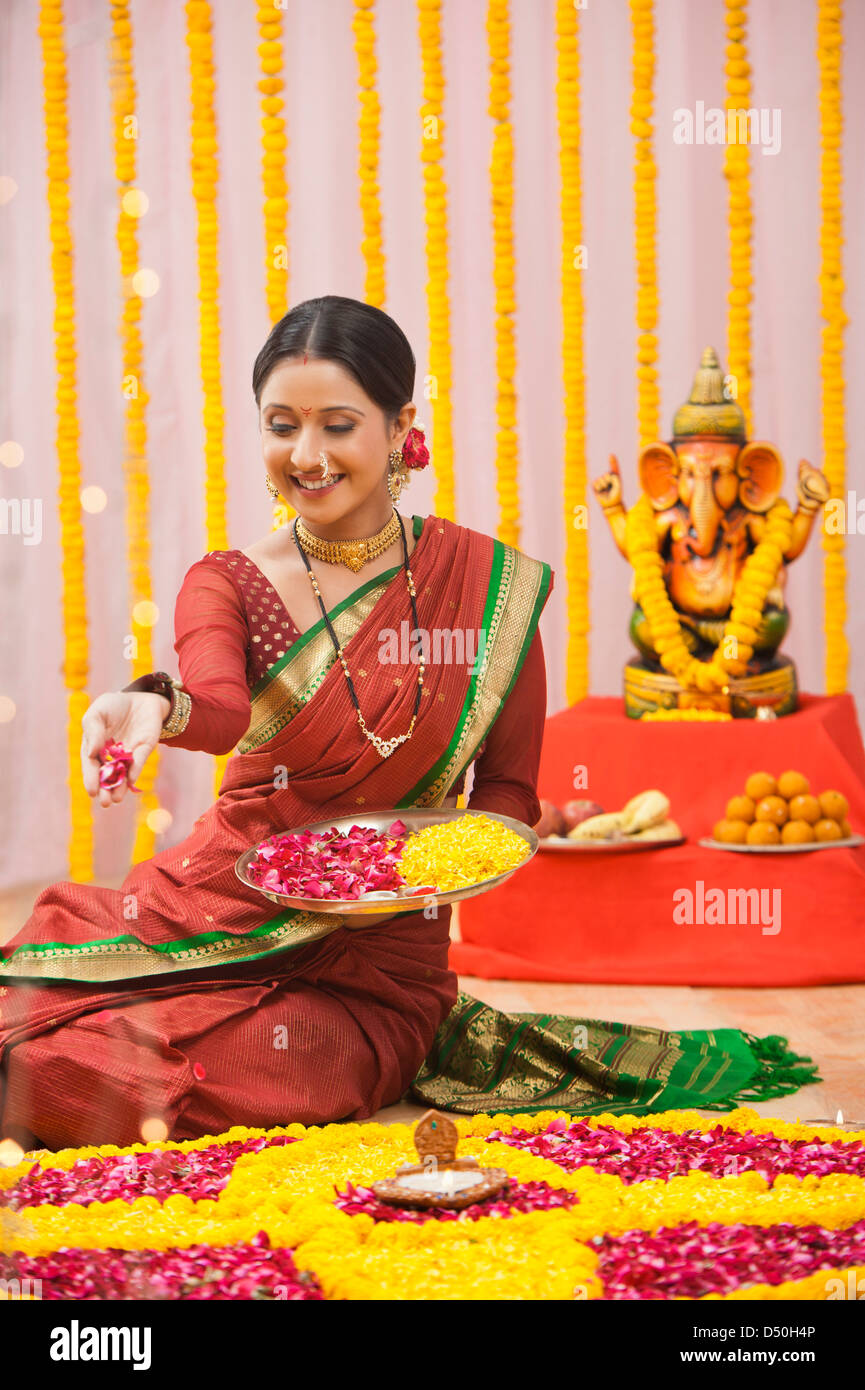 Maharashtrian woman making a rangoli at Ganesh Chaturthi Stock Photo