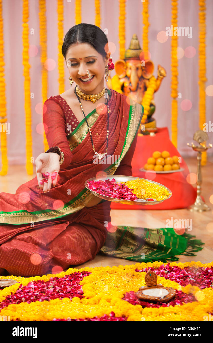 Maharashtrian woman making a rangoli at Ganesh Chaturthi Stock Photo