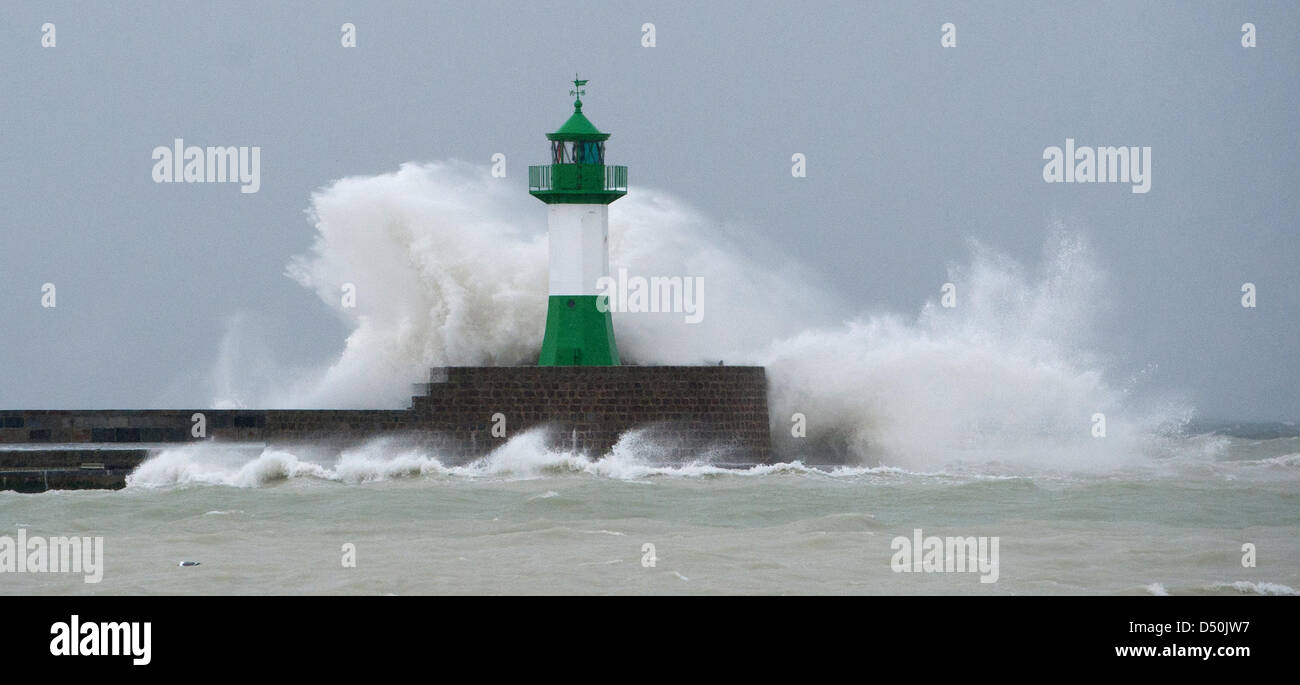 A wave hits a lighthouse at the 1.440 metres long mole in the port of Sassnitz, Rugia, Germany, 29 November 2010. The first autumn storm has reached the Baltic Sea and flooded many beaches during the same day. The Ministry for Maritime Transport and Hydgrography in Rostock, Germany expect water levels of up to 1 metre above average, in extreme cases even 1,20 meters, for the aftern Stock Photo