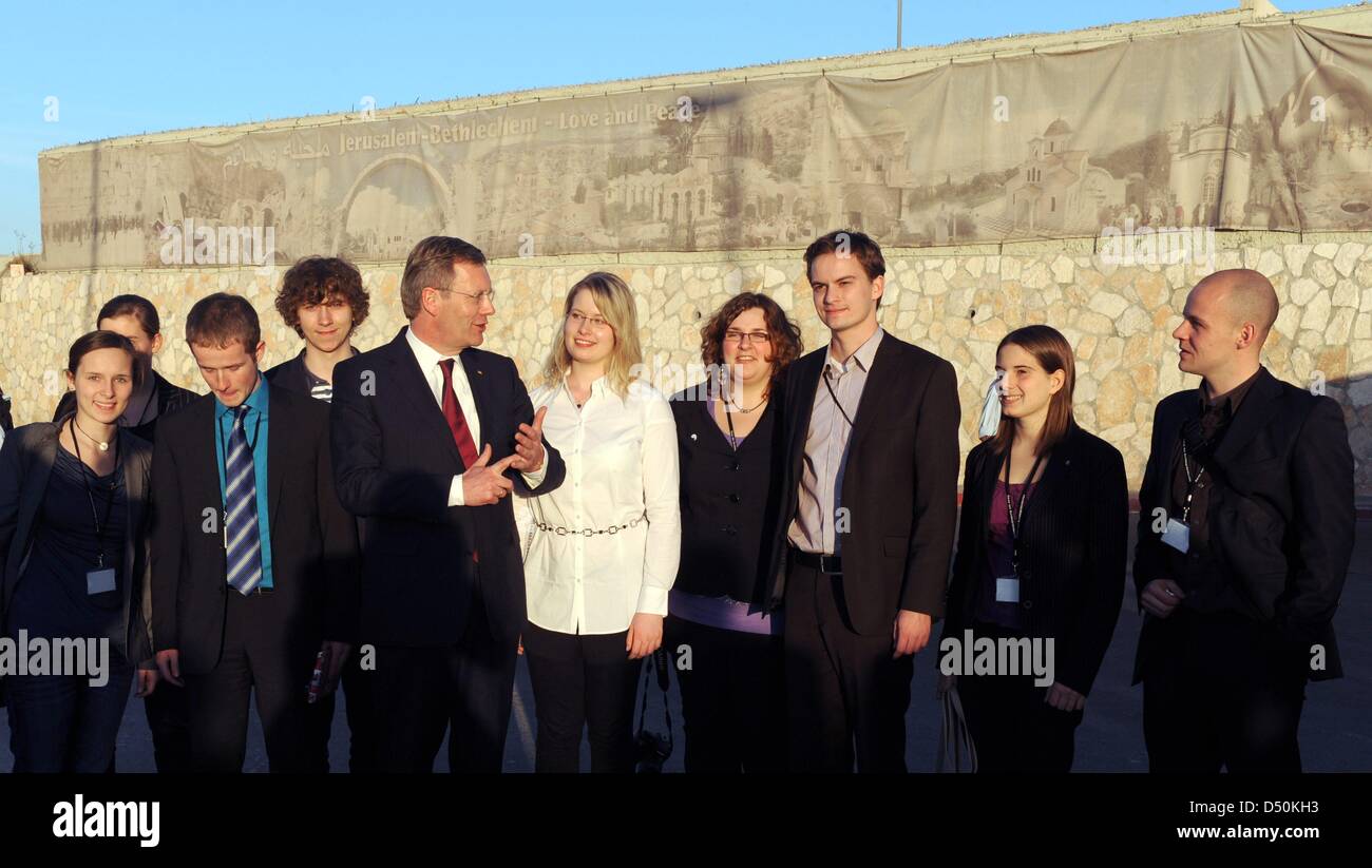 'Jerusalem - Bethlehem - Love and Peace' is writen above the heads of German President Christian Wulff and his daughter Annalena (white blouse), that stand next to a group of young German visitors at the check point 'Rachel's Grave' between Bethlehem and Jerusalem, Israel, 30 November 2010. A group of juveniles belong to Wulff's delegation and met other people of the same age in Is Stock Photo