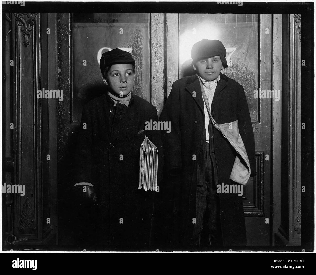 In a saloon doorway at 8:30 P.M. Left to right, George Cappello, 12 years old. Frank Laporter, 13 years old. Utica, N.Y., February 1910 Stock Photo