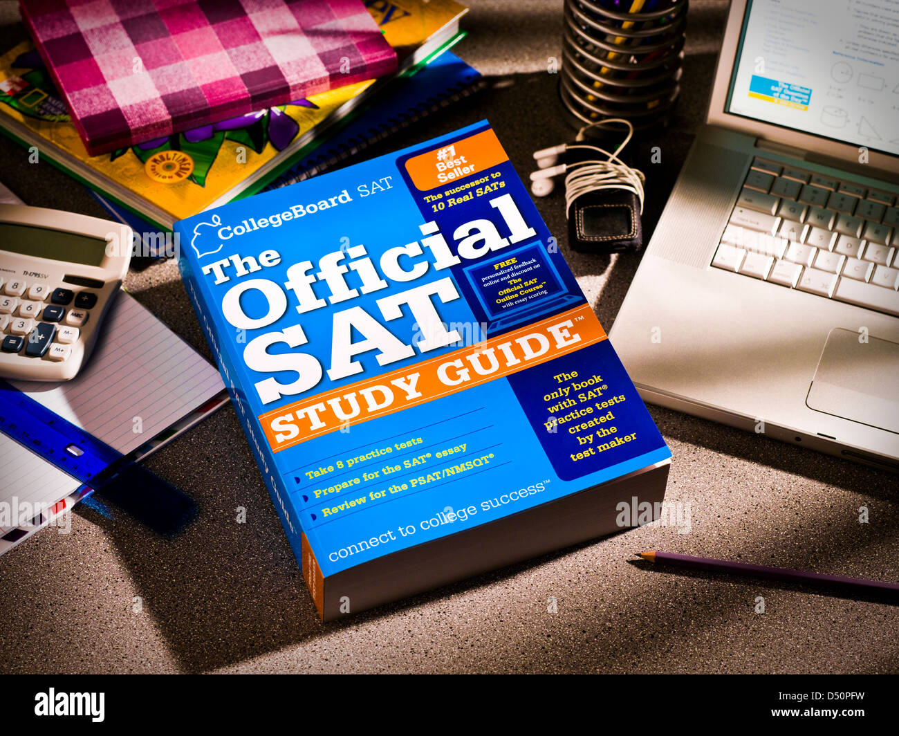 Still life of students desktop showing SAT study guide, laptop and books.
