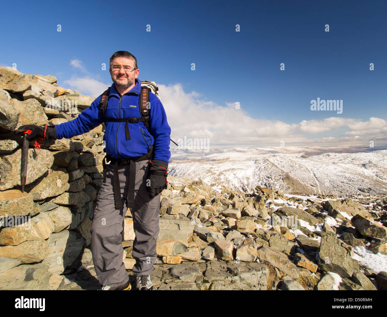 A walker on the summit of Scafell Pike, Lake district, UK, the highest peak in England. Stock Photo