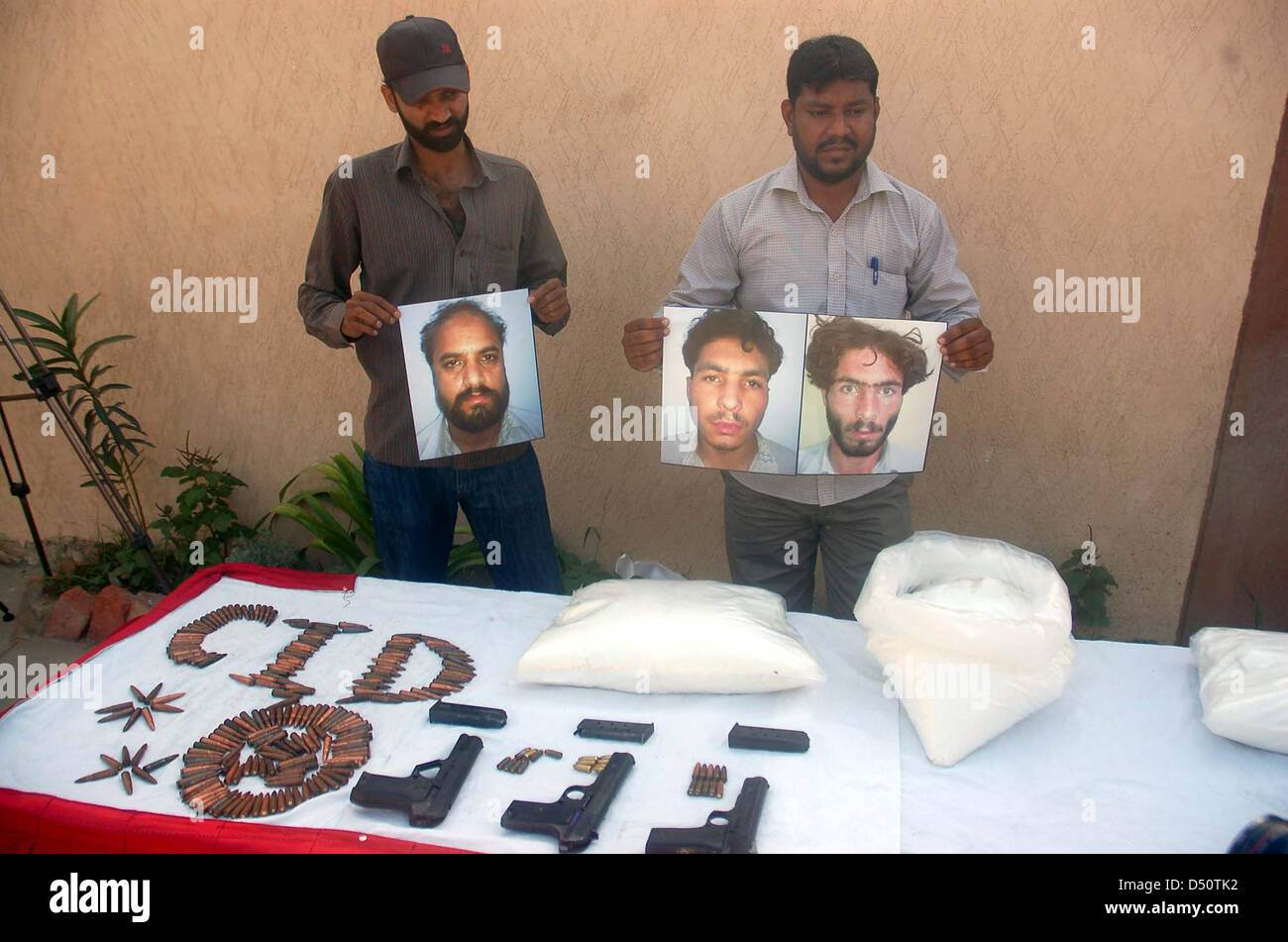 CID Counter Terrorism Wing Officials showing seized  weapons during press conference as the CID officials detained three activists of Lashkar-e- Jhangvi during snap checking as they were transferring explosive materials from Baloch Colony  to Kanwari Colony, at CID Counter Terrorism Wing office Garden headquarters in Karachi on  Thursday, March 21, 2013. CID Counter Terrorism Wing seized 20 Kilograms of Potassium  Nitrate used in making bombs and 03 9mm Pistols and numerous bullets that recovered from  them. Stock Photo