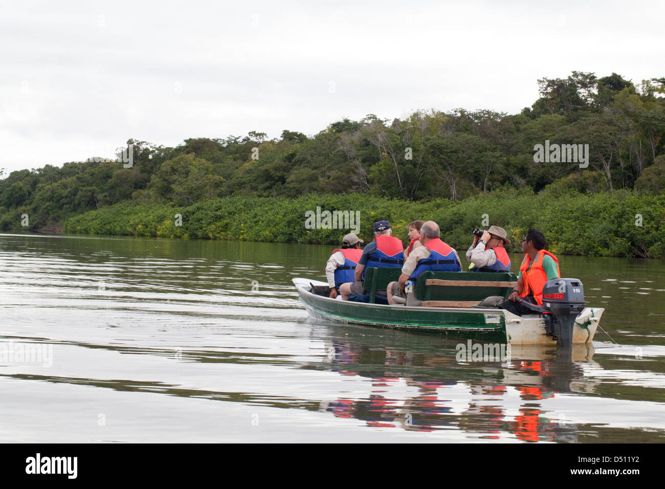 Eco-tourists and local guides travel aboard a motorised boat on River Rewa/Rupununi. North Rupununi. Guyana. Stock Photo