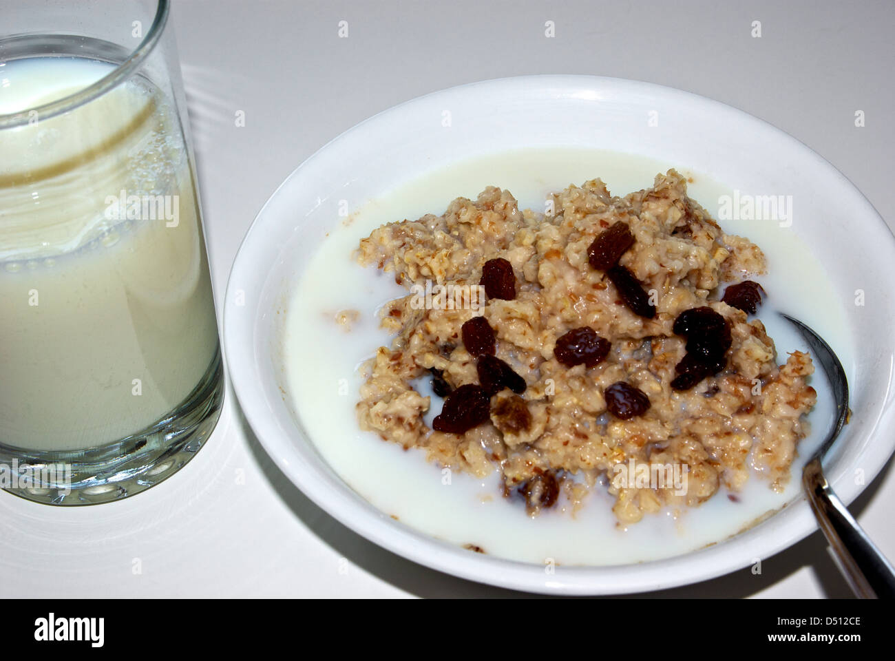 Bowl cooked oatmeal cereal glass skim milk Sultana raisins Stock Photo Alamy