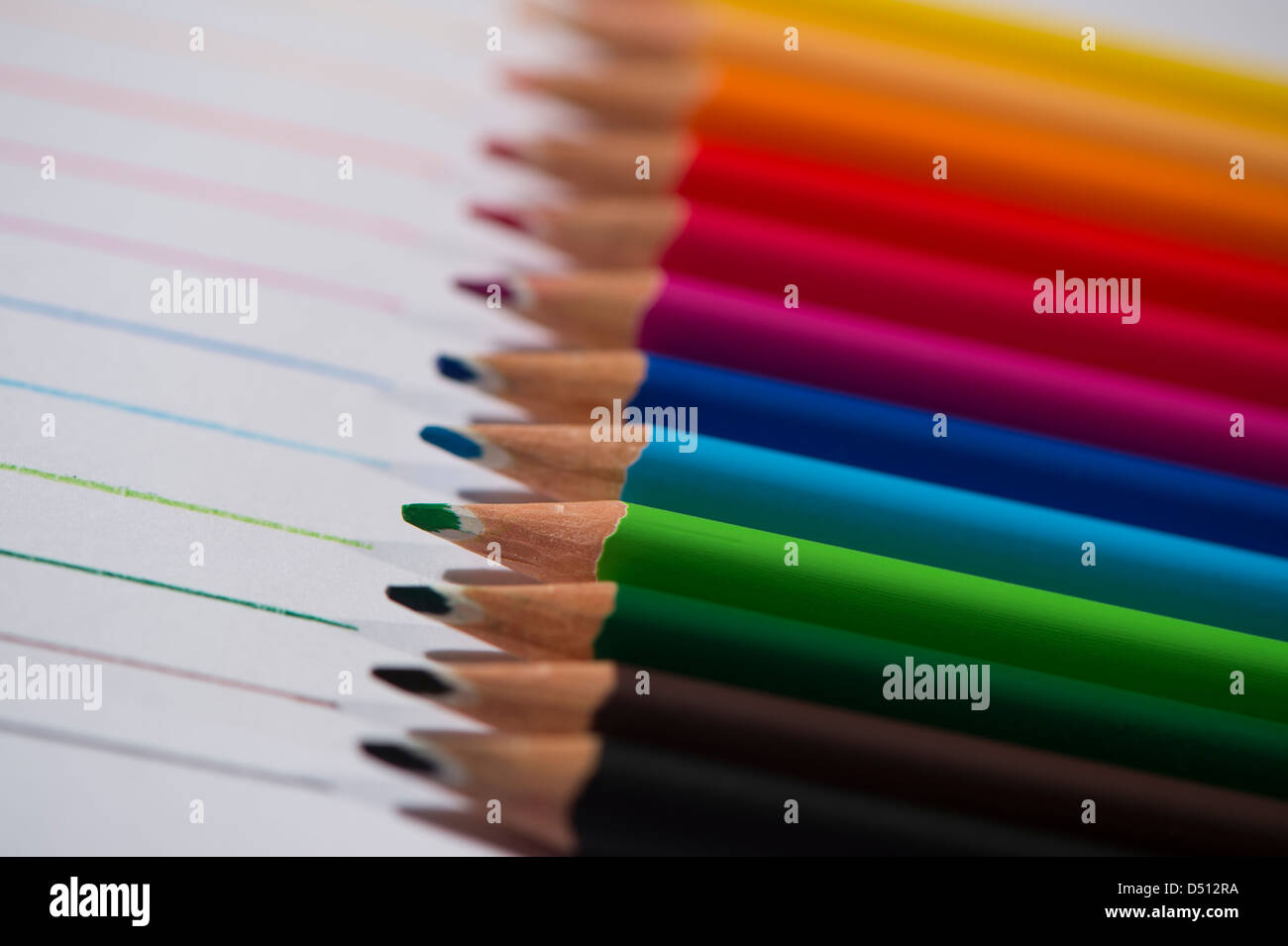 Close-up detail of sharp colourful pencil crayons laid side by side on  white paper background by lines drawn in each colour - Yorkshire, England,  UK Stock Photo - Alamy