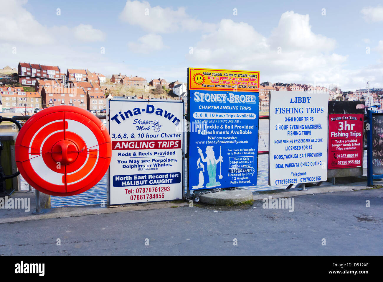 Notices advertising the several boats offering sea angling trips from New Quay at Whitby Stock Photo