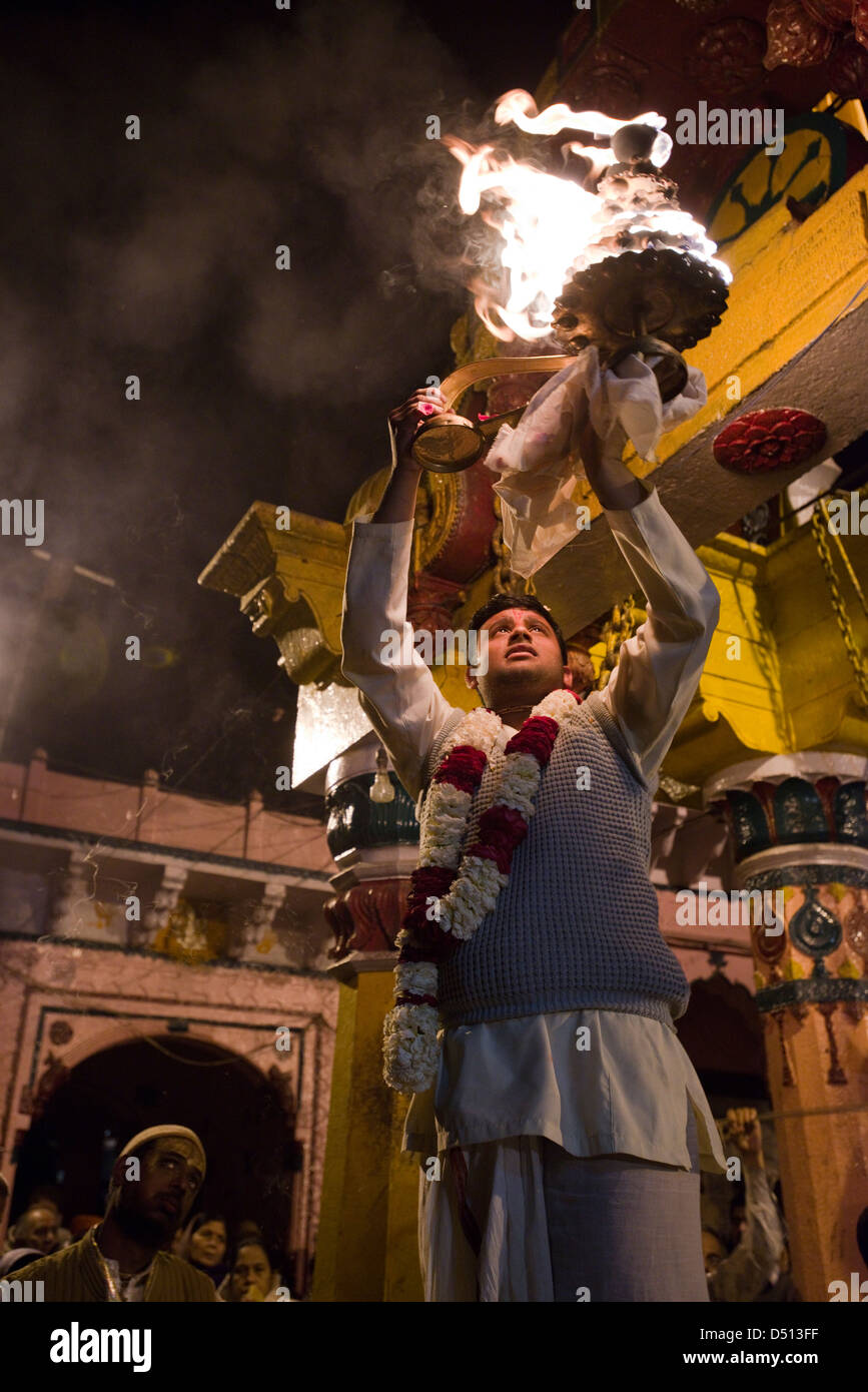 A Hindu high priest raises a sacred fire of camphor offerings at Vishram Ghat, Mathura, Uttar Pradesh, India Stock Photo