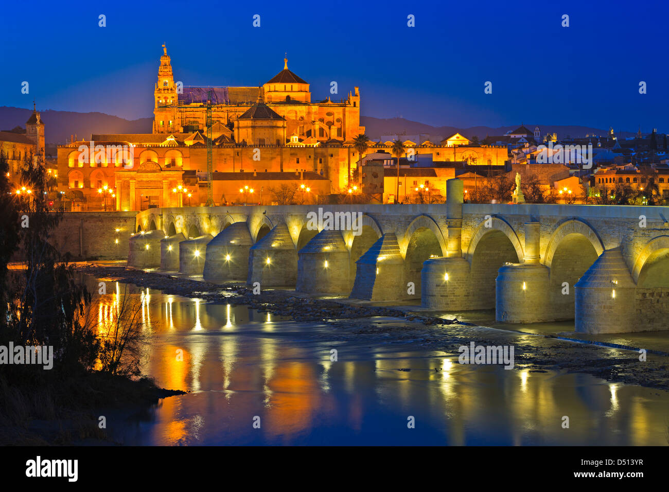Puente Romano (bridge) and the Mezquita (Cathedral-Mosque) during dusk in the City of Cordoba, Andalusia, Spain Stock Photo