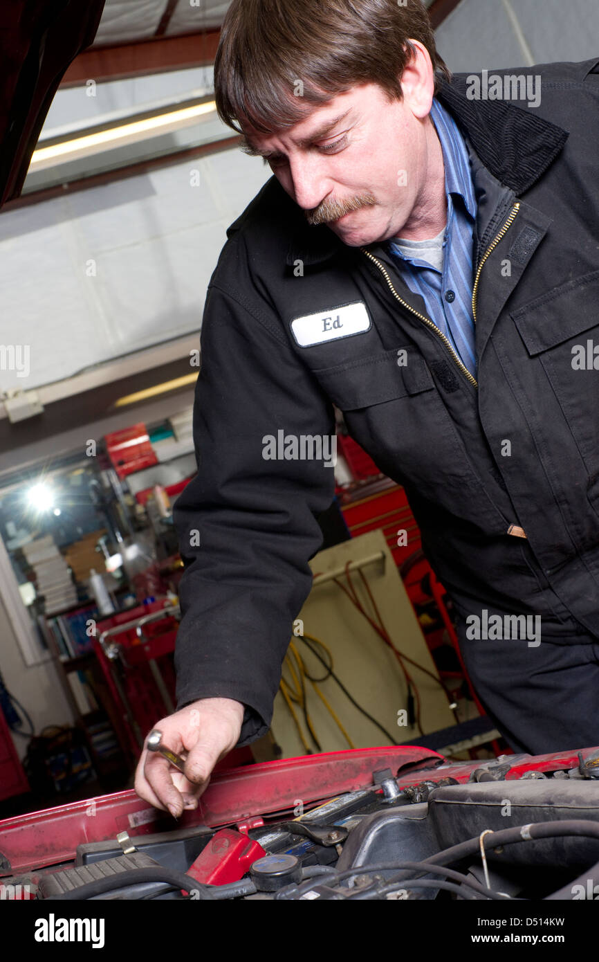 Mechanic examining under hood car hires stock photography and images