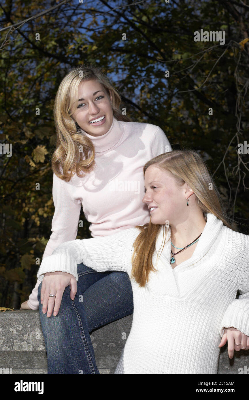 Two Caucasian teen age girls smiling and hanging out in a park. Stock Photo