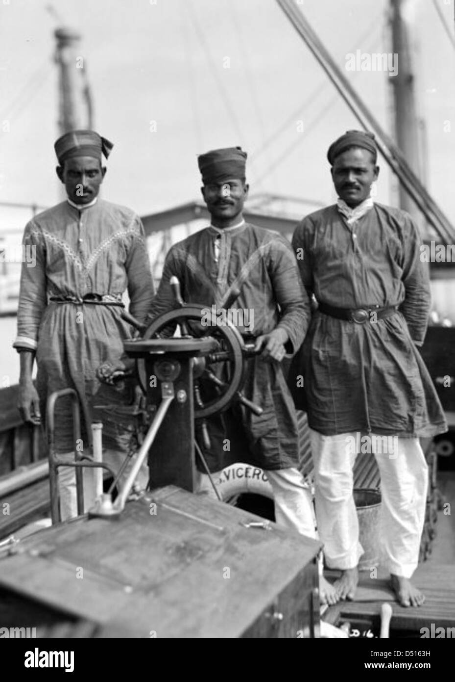 Three Lascars of the 'Viceroy of India', standing behind the wheel of one of the ship's tenders Stock Photo