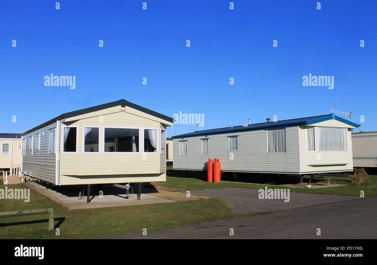 Caravans parked in modern trailer park with blue sky background. Stock Photo