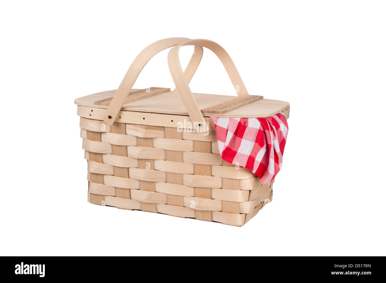 A new wicker and wood picnic basket with a red checkered tablecloth peeking out the side. Isolated on white. Stock Photo