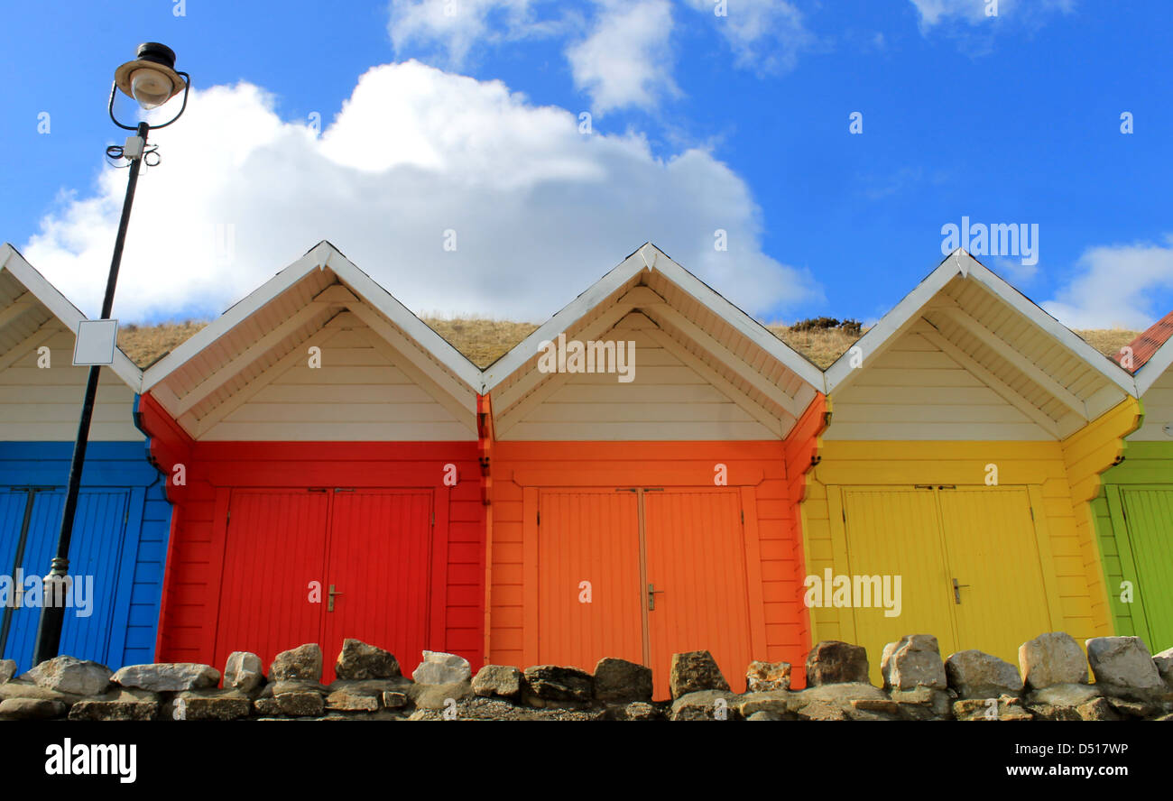 Row of colorful beach chalets with blue sky background. Stock Photo