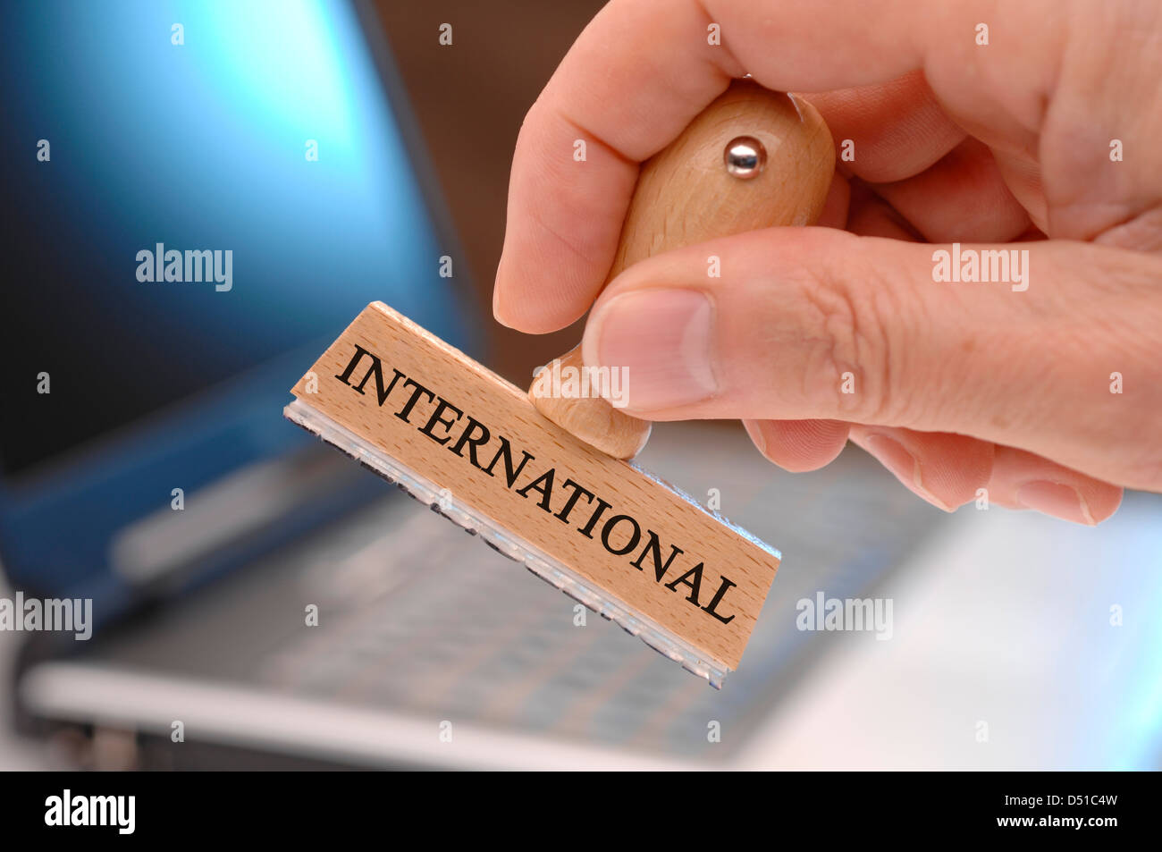 rubber stamp in hand marked with international Stock Photo