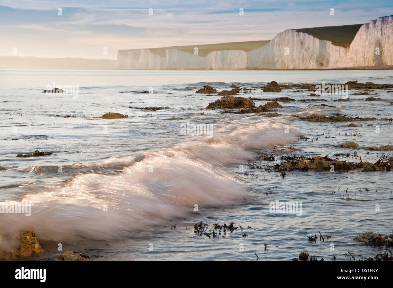 Stunning Summer sunset over ocean with cliffs, rocks and vibrant colors ...