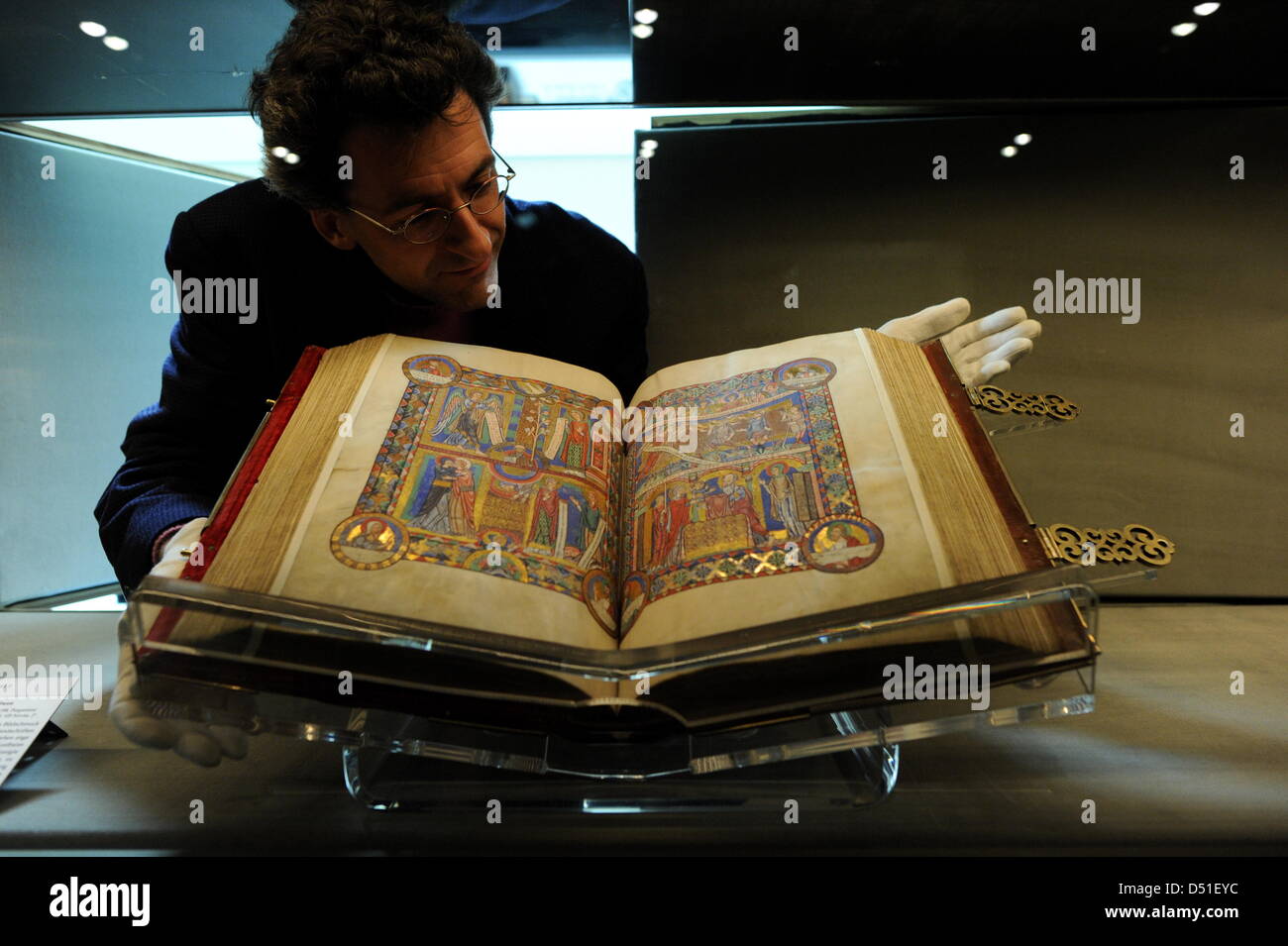 Christian Heitzmann, head of the handwriting department of the Herzog August Library in Wolfenbuettel, arranges the gospel book of Heinrich the Lion, that will be on display until 08 December 2010, at the exhibition space of the library in Wolfenbuettel, Germany, 08 December 2010. The gospel book from the 12th-century is renowned as a showpiece of midieval book art and is one of th Stock Photo