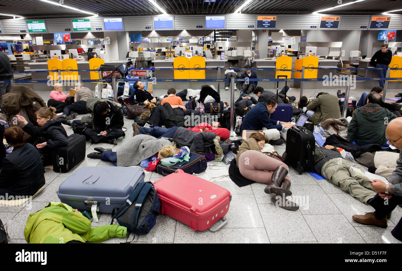 Passengers sleep near the counters of terminal one at the airport in