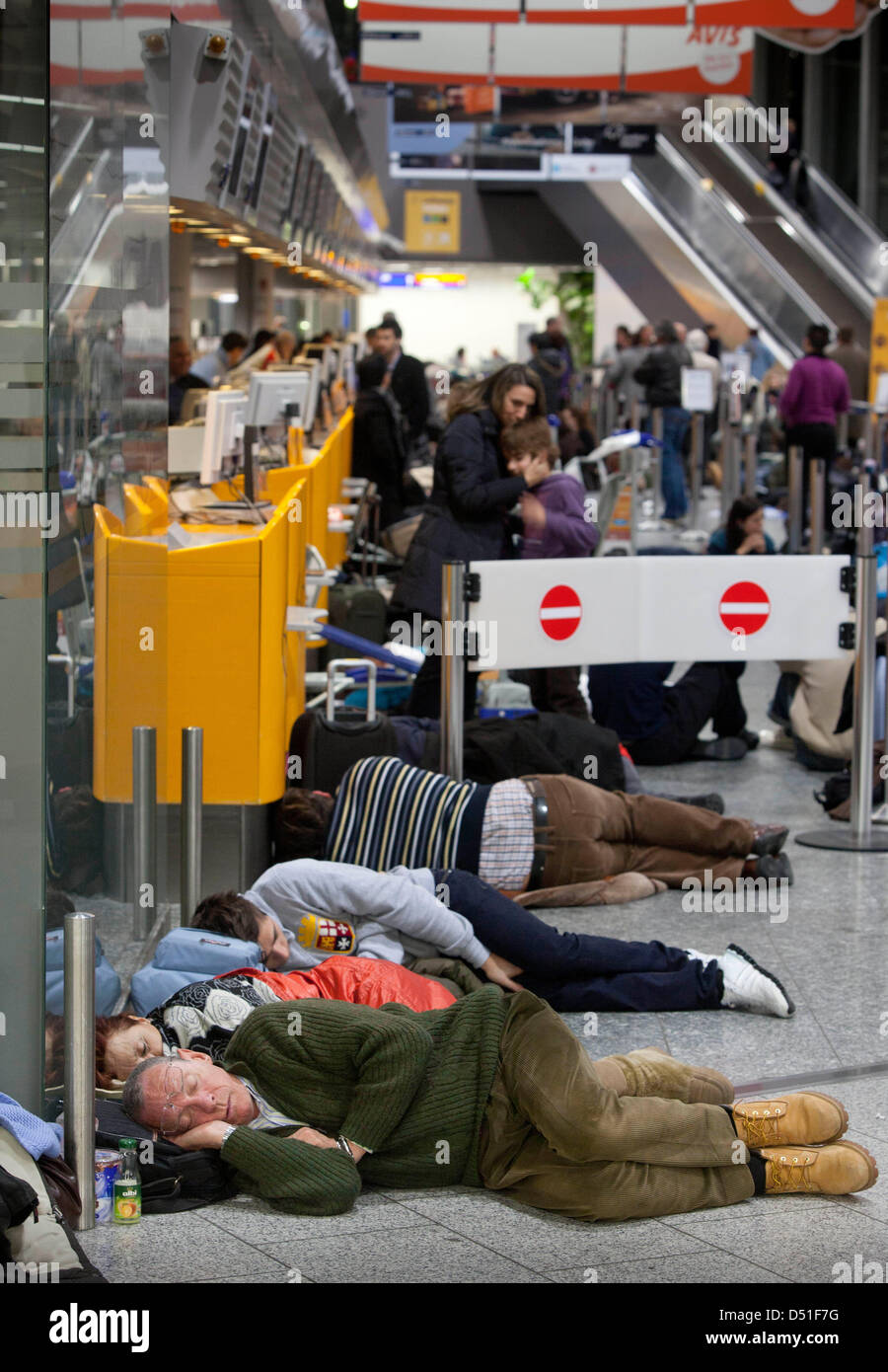 Passengers sleep near the counters of terminal one at the airport in