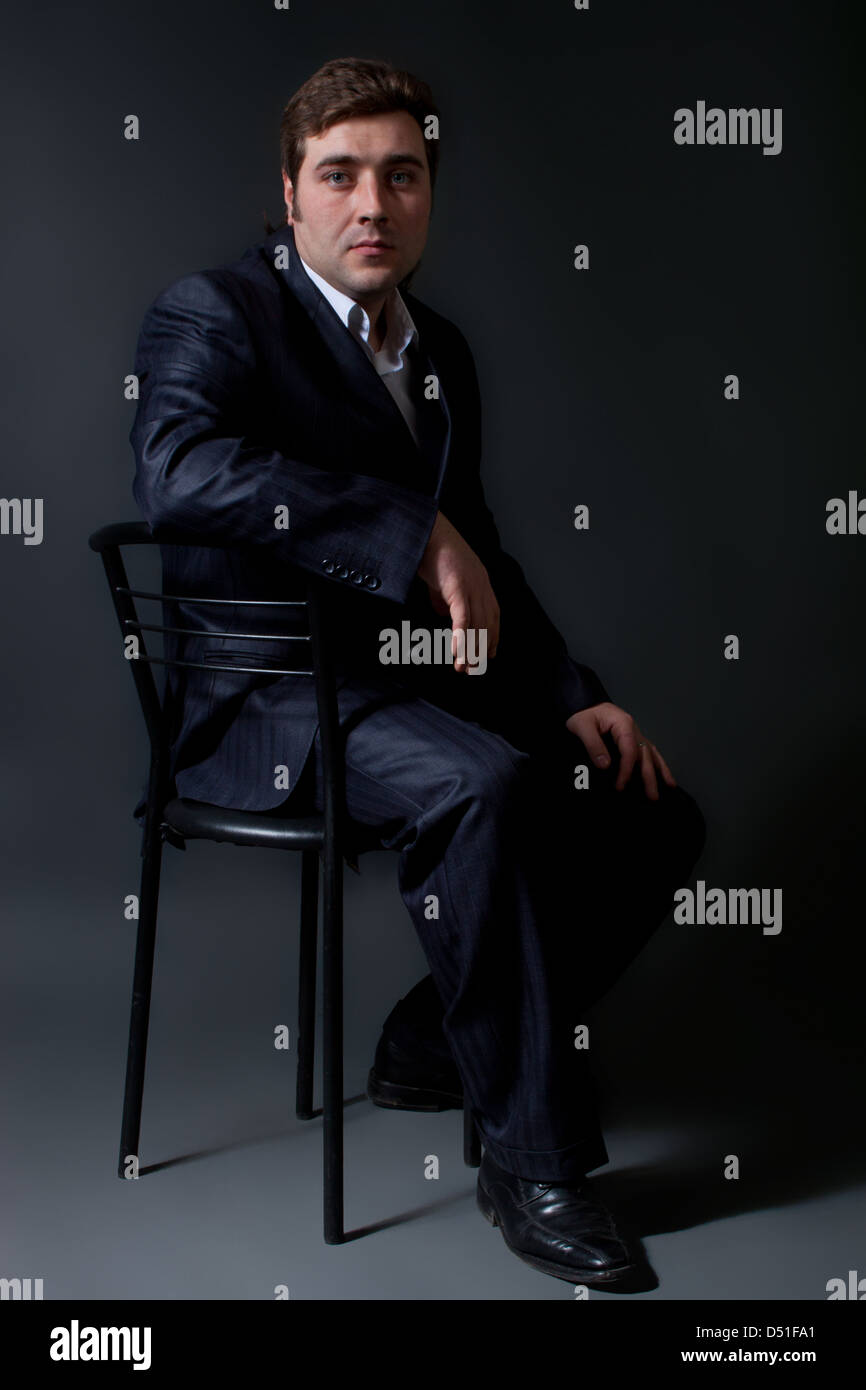 portrait of a young man in a black suit with a gray background Stock ...