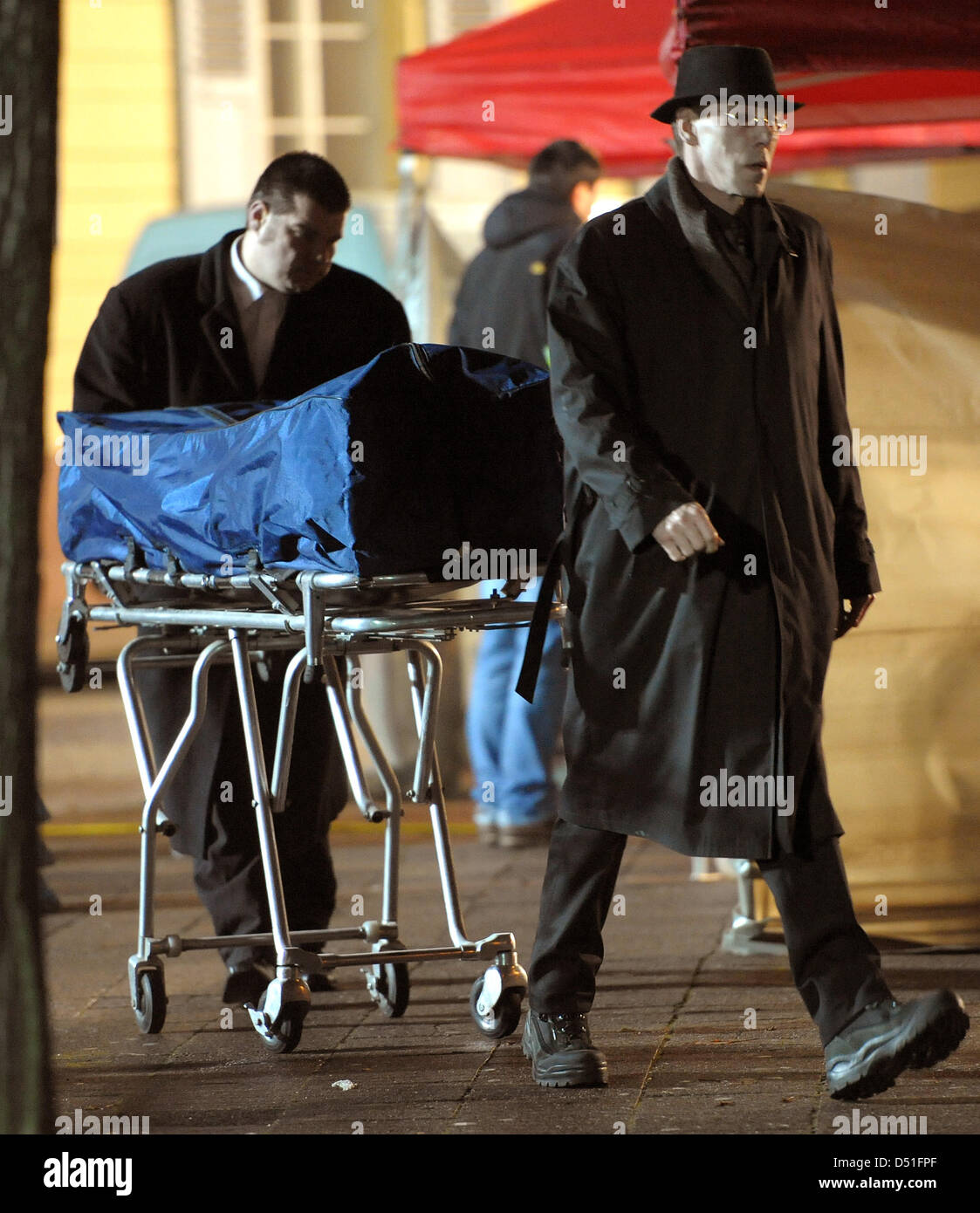Two undertakers bring the dead body of one of the bank robbers to a car after a bank hold-up in Karlsruhe, Germany, 10 December 2010. In the course of a bank hold-up on a highly frequented shopping street, the police shot the two bank robbers, a man and a woman, dead. A female police officer was severely injured during the operation. Photo: Ronald Wittek Stock Photo