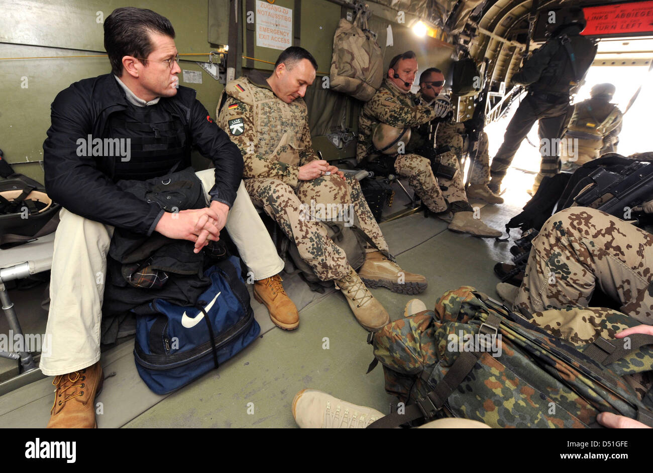 German Defence Minister Karl-Theodor zu Guttenberg sits together with soldiers in a helicopter on the way to the military camp in Kunduz, Afghanistan, 13 December 2010. German Defence Minister Karl-Theodor zu Guttenberg visits the German Bundeswehr soldiers of the ISAF mission contingent in Afghanistan. Photo: MAURIZIO GAMBARINI Stock Photo