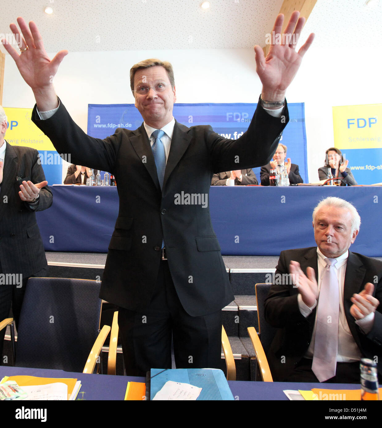 Free Democratic Party federal chairman and German Foreign Minister Guido Westerwelle (L) waves goodbye after having held a speech as the Free Democrats' parliamentary group chairman Wolfgang Kubicki applauds at a party convention of Schleswig-Holstein's FDP in Elmshorn, Germany, 06 November 2010. Mr Kubicki has expressed sympathy for Mr Westerwelle in light of his unflattering port Stock Photo