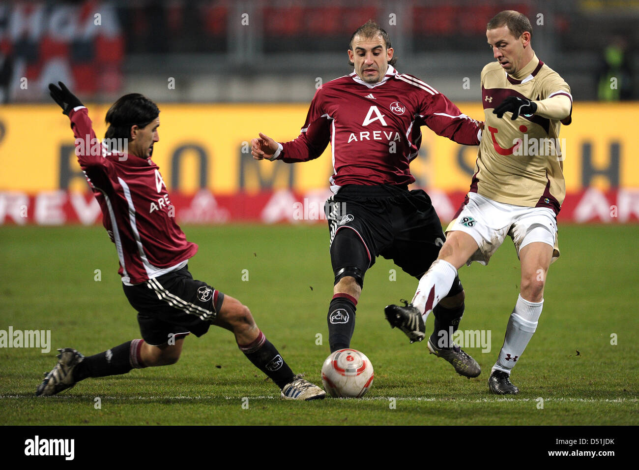 Nuremberg's Almog Cohen (L) and Javier Pinola (C) challenge Hanover's Jan Schlaudraff (R) during German Bundesliga match 1.FC Nuremberg v Hanover 96 at easyCredit stadium in Nuremberg, Germany, 18 December 2010. Nuremberg defeated Hanover with 3-1. Photo: DAVID EBENER (ATTENTION: EMBARGO CONDITIONS! The DFL permits the further utilisation of the pictures in IPTV, mobile services an Stock Photo