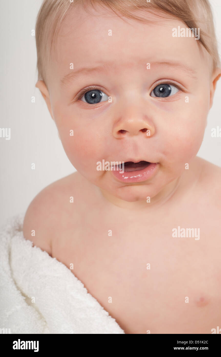 Happy little boy in white blanket in studio Stock Photo Alamy