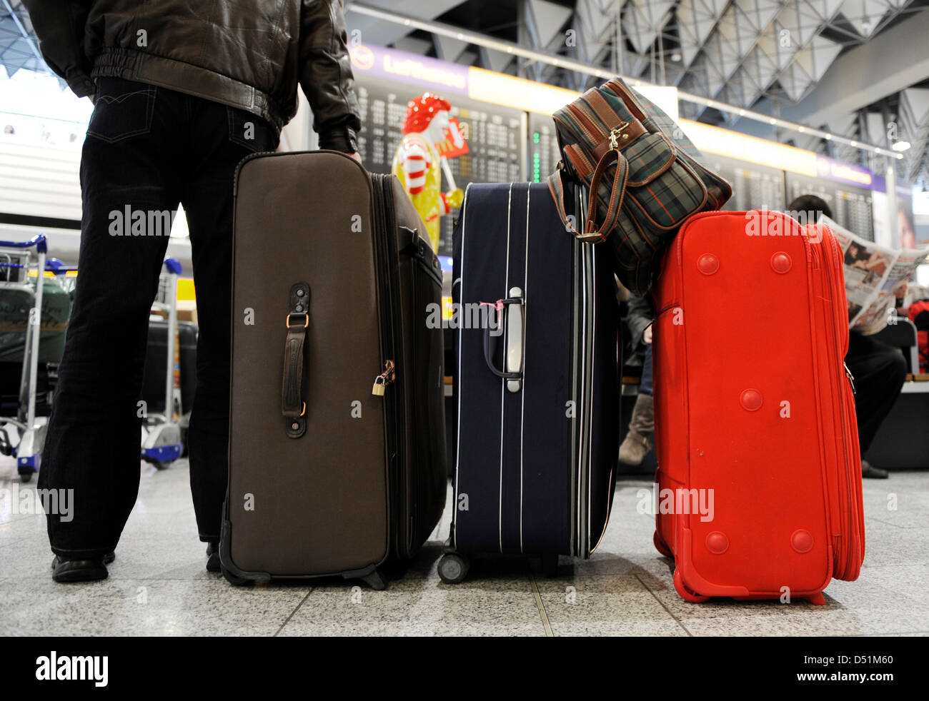 Air passengers wait for their departures with their baggage at the ...