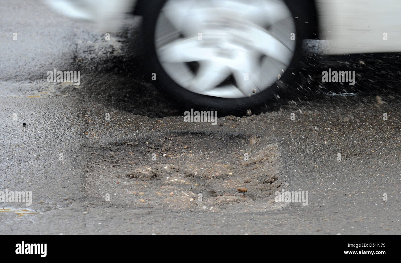 A car drives over a road hole on a street in Mannheim, Germany, 30