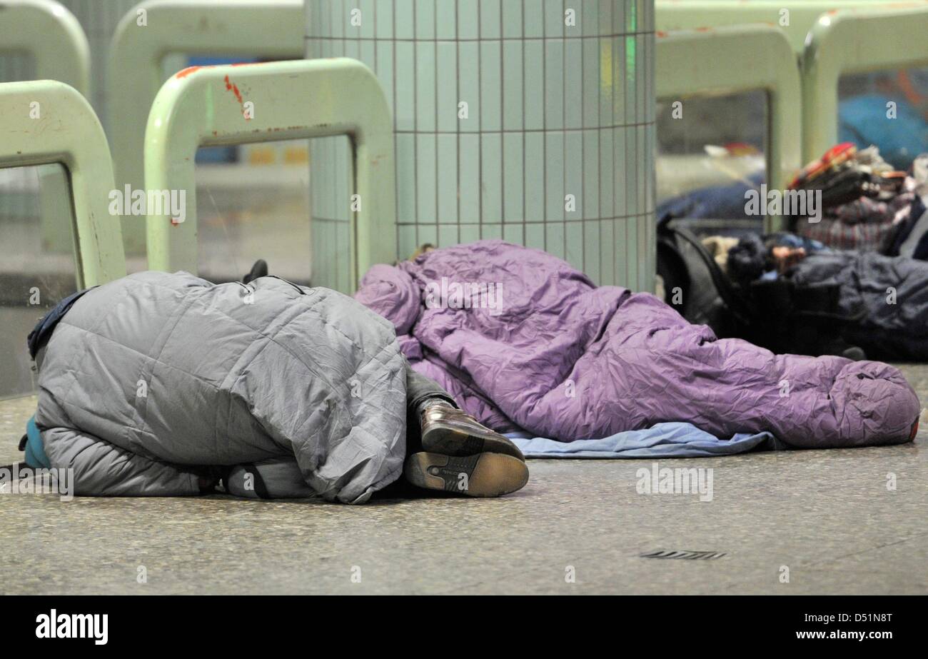 Homeless people sleep at the Hauptwache wrapped in sleeping bags and