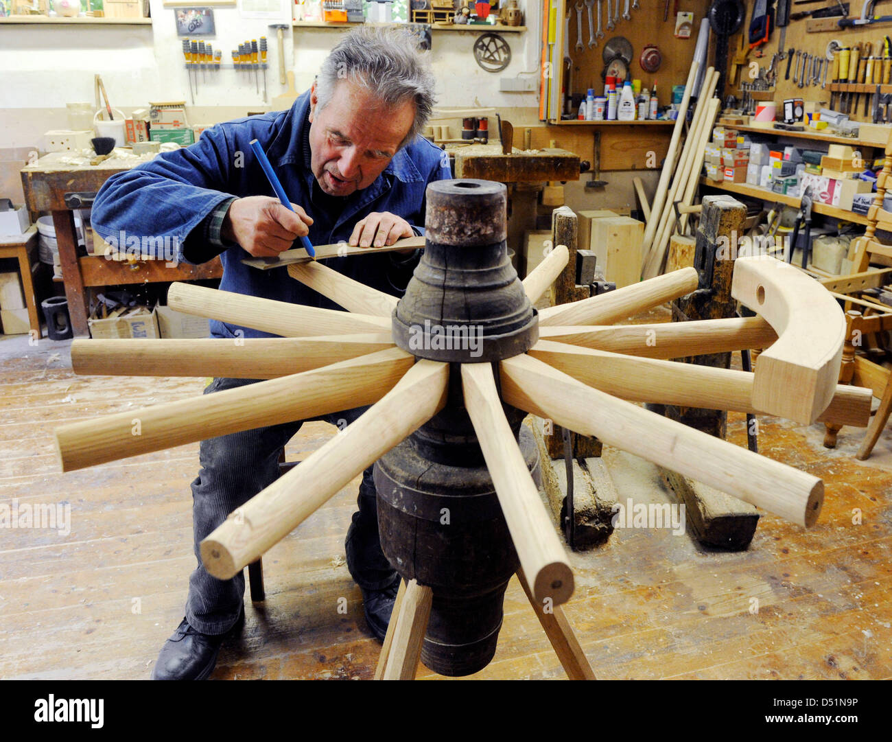 Waggonmaker Karl Renz works on a wheel of a waggon in his shop in
