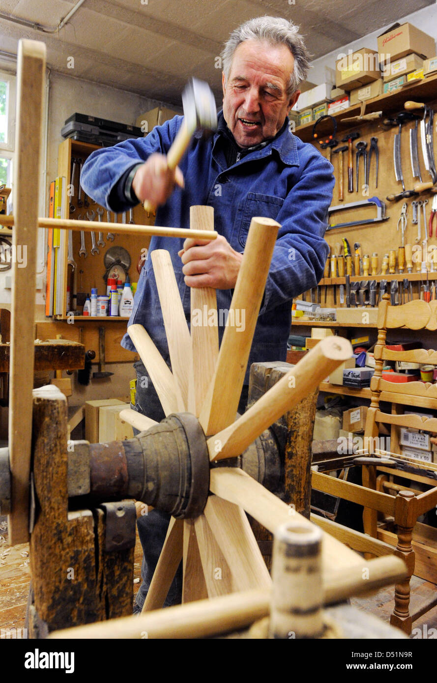 Waggon-maker Karl Renz works on a wheel of a waggon in his shop in Oberderdingen, Germany, 27 October 2010. As one of the last of his profession, he makes wooden wheels and repairs them. Photo: Uli Deck Stock Photo