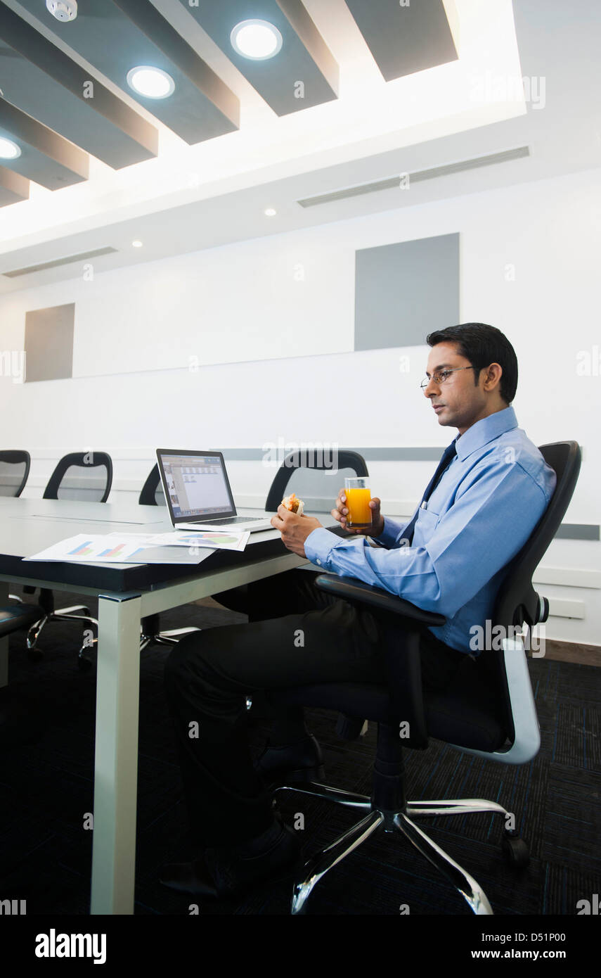 Businessman reviewing pie chart and having food Stock Photo Alamy
