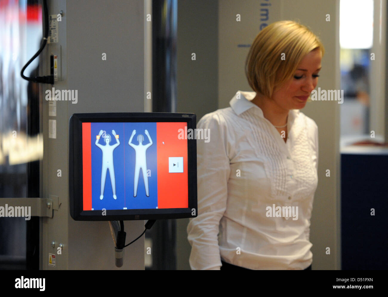 A woman walks through a body scanner at the airport in Hamburg, Germany ...