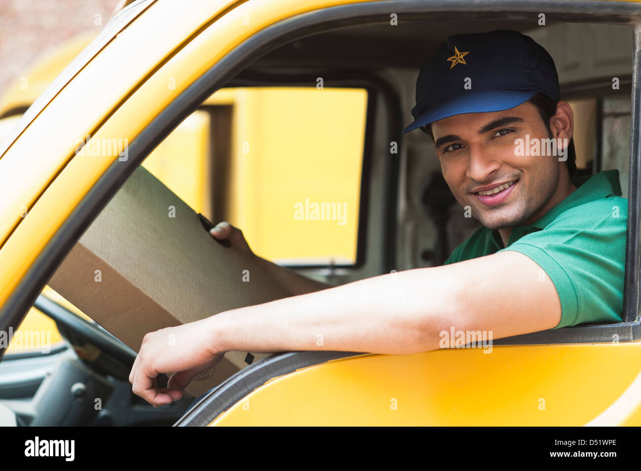 Delivery man sitting in his van and smiling Stock Photo - Alamy