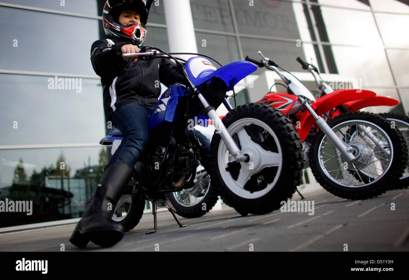 A child poses for a picture on a Yamaha children's motocross cycle at ...