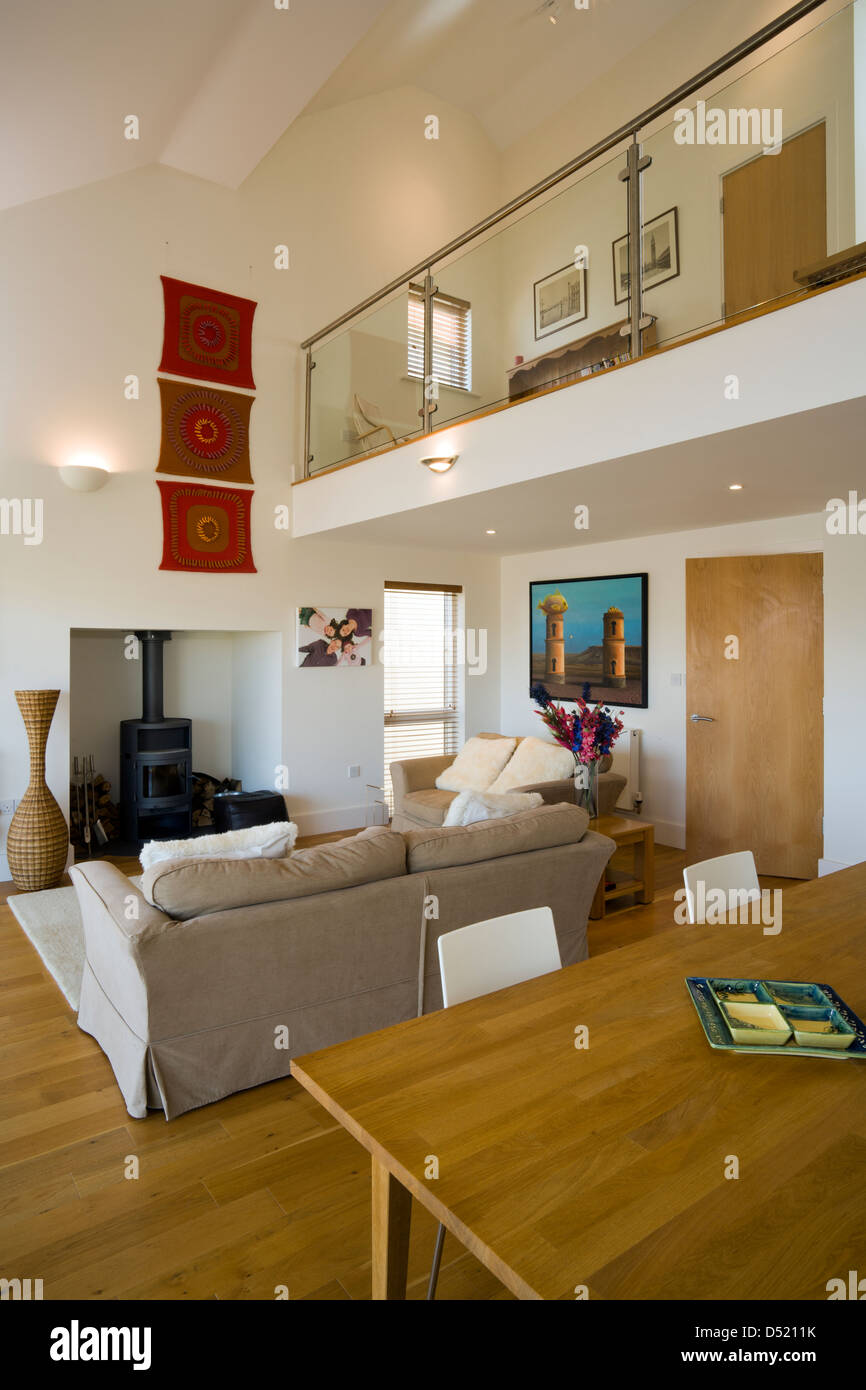 An open plan living dining room with a high ceiling and a small mezzanine. Stock Photo