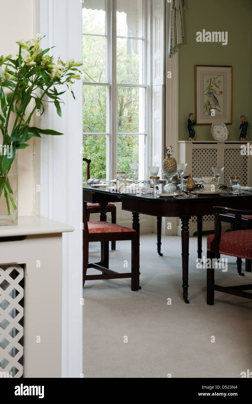 A view through a doorway to a traditional dining room with a laid table