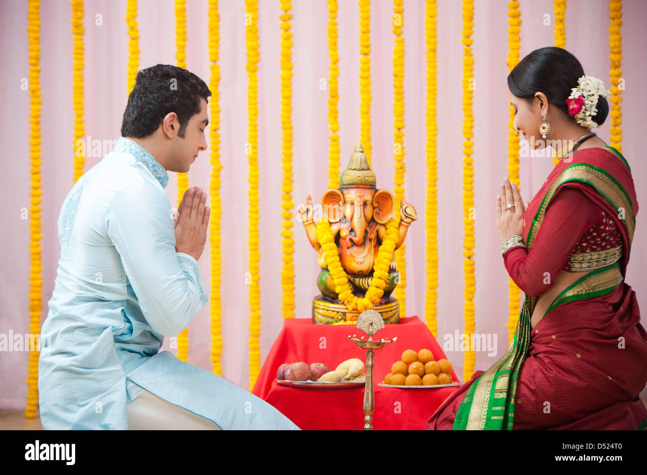 Maharashtrian couple praying Lord Ganesha during ganesh chaturthi