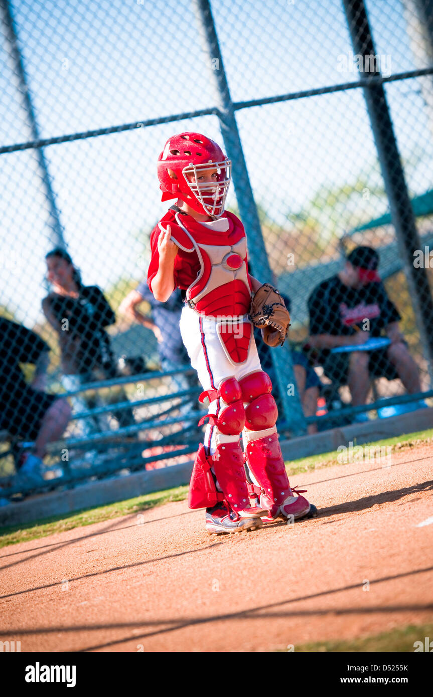 Little league baseball catcher standing up at home plate looking Stock