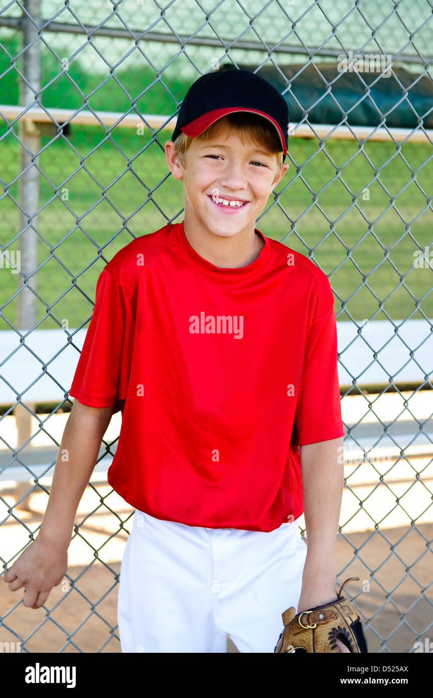 LIttle league baseball player leaning on dugout fence Stock Photo Alamy