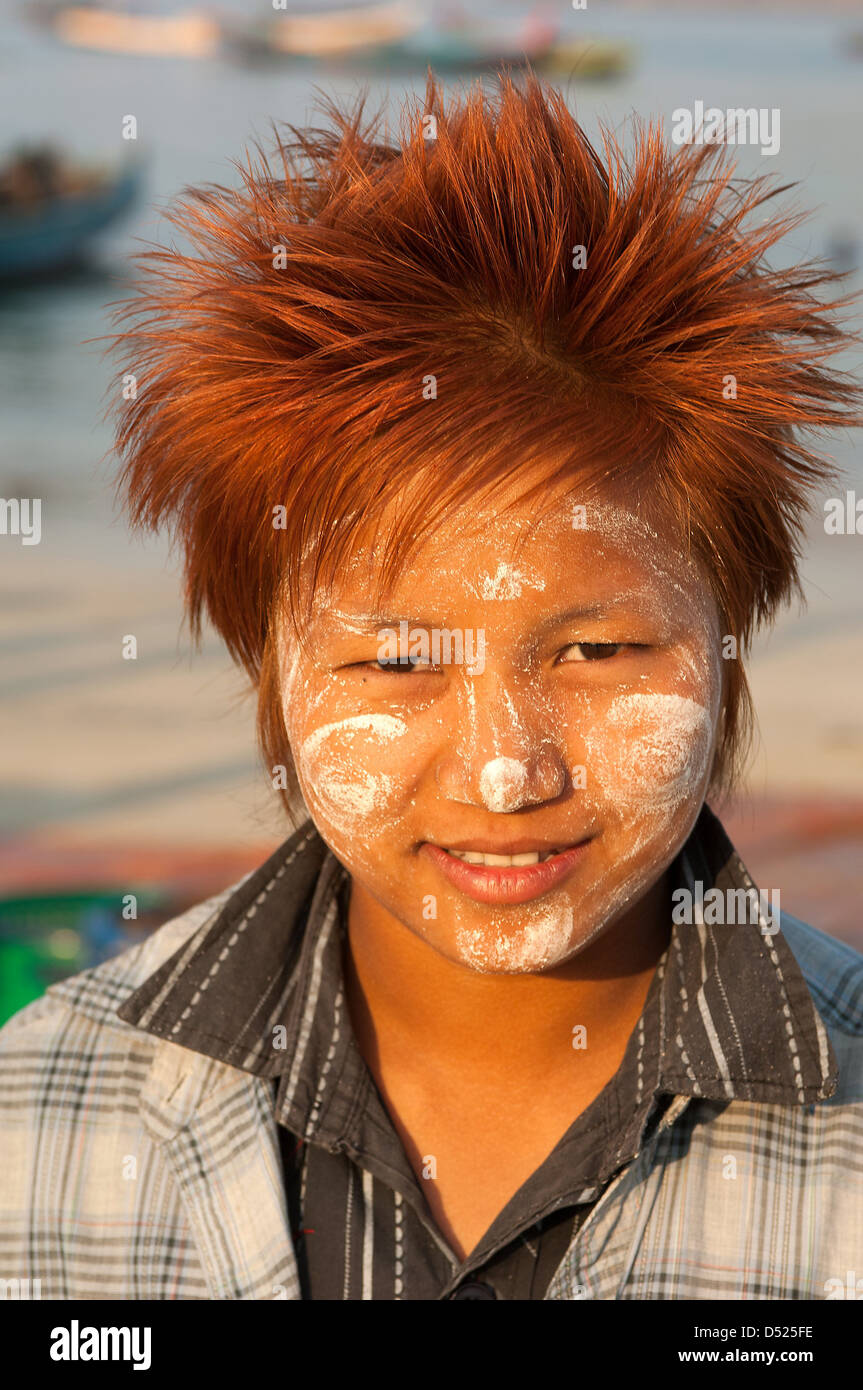 This young Burmese woman has rubbed Thanaka bark paste on her face to protect it against the sun and died her hair too. Stock Photo