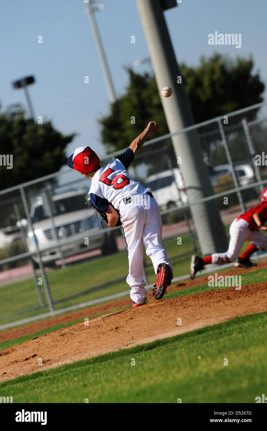 Little league baseball pitcher throwing to first base Stock Photo Alamy