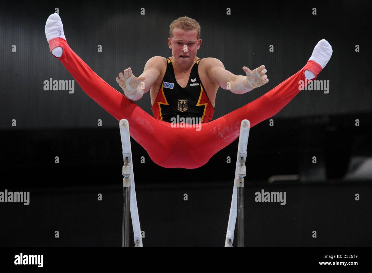 German gymnast Fabian Hambuechen performs his skills on the bars during the team final of the